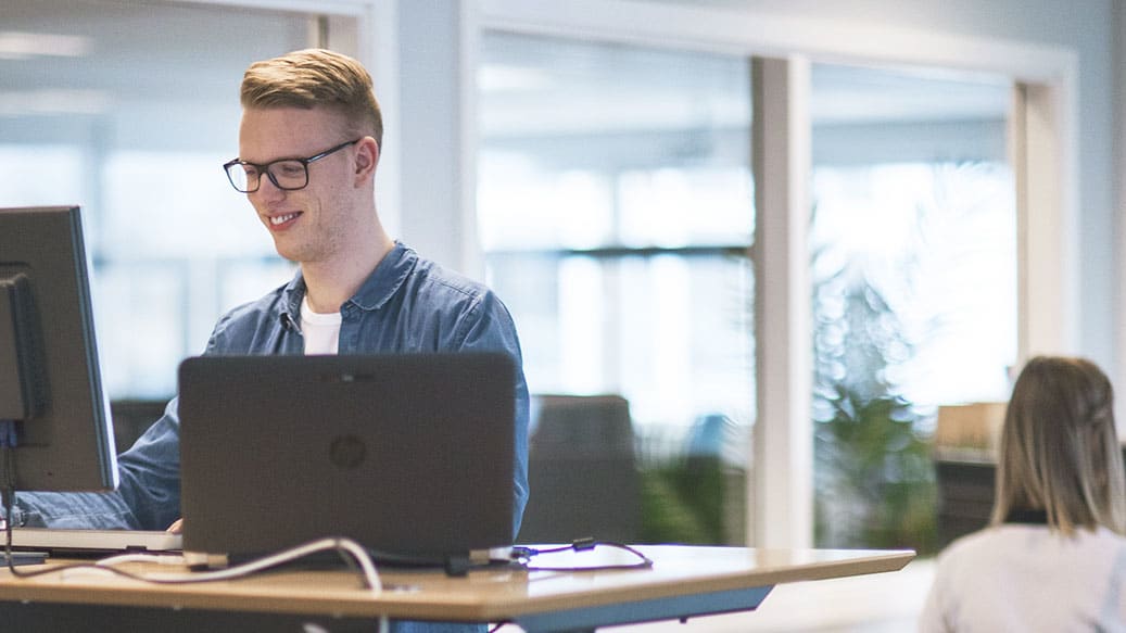 Person står op ved skrivebord og arbejder