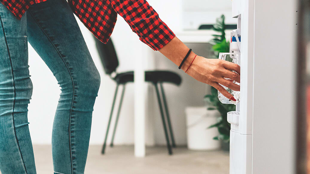 Person fylder et glas vand ved vanddispenser_drikker du nok vand i løbet af dagen_artikel