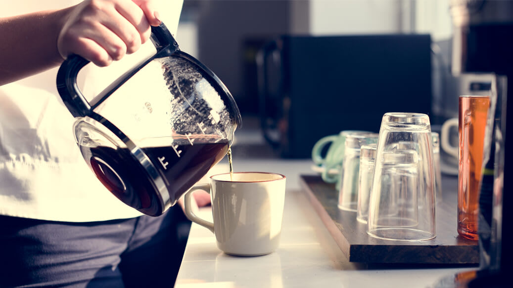 Person hælder en kop kaffe op i sin mikropause