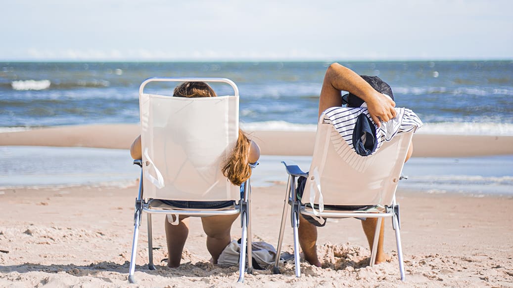 Afkobling i ferien_2 personer sidder i en strandstol
