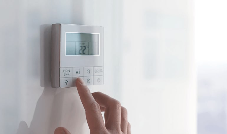 Person trykker på display i termostat
